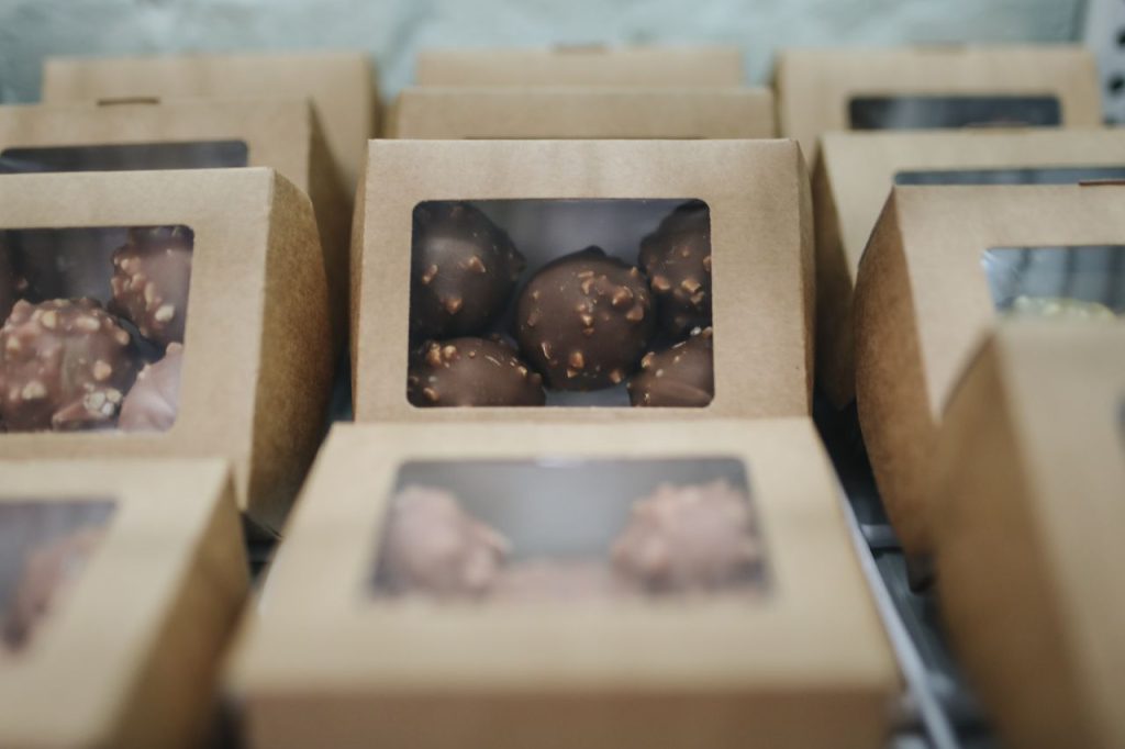 Close-up of assorted chocolates packaged in cardboard boxes for sale.